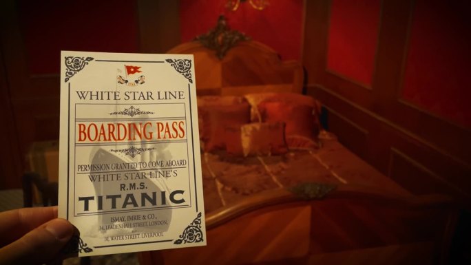 1912年，一名男子在泰坦尼克号的房间里举着泰坦尼克号的登机牌