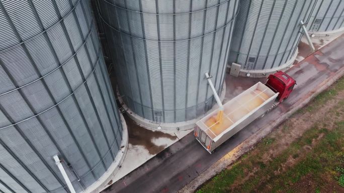 慢动作无人机拍摄谷仓装满拖车卡车的粮食在农场