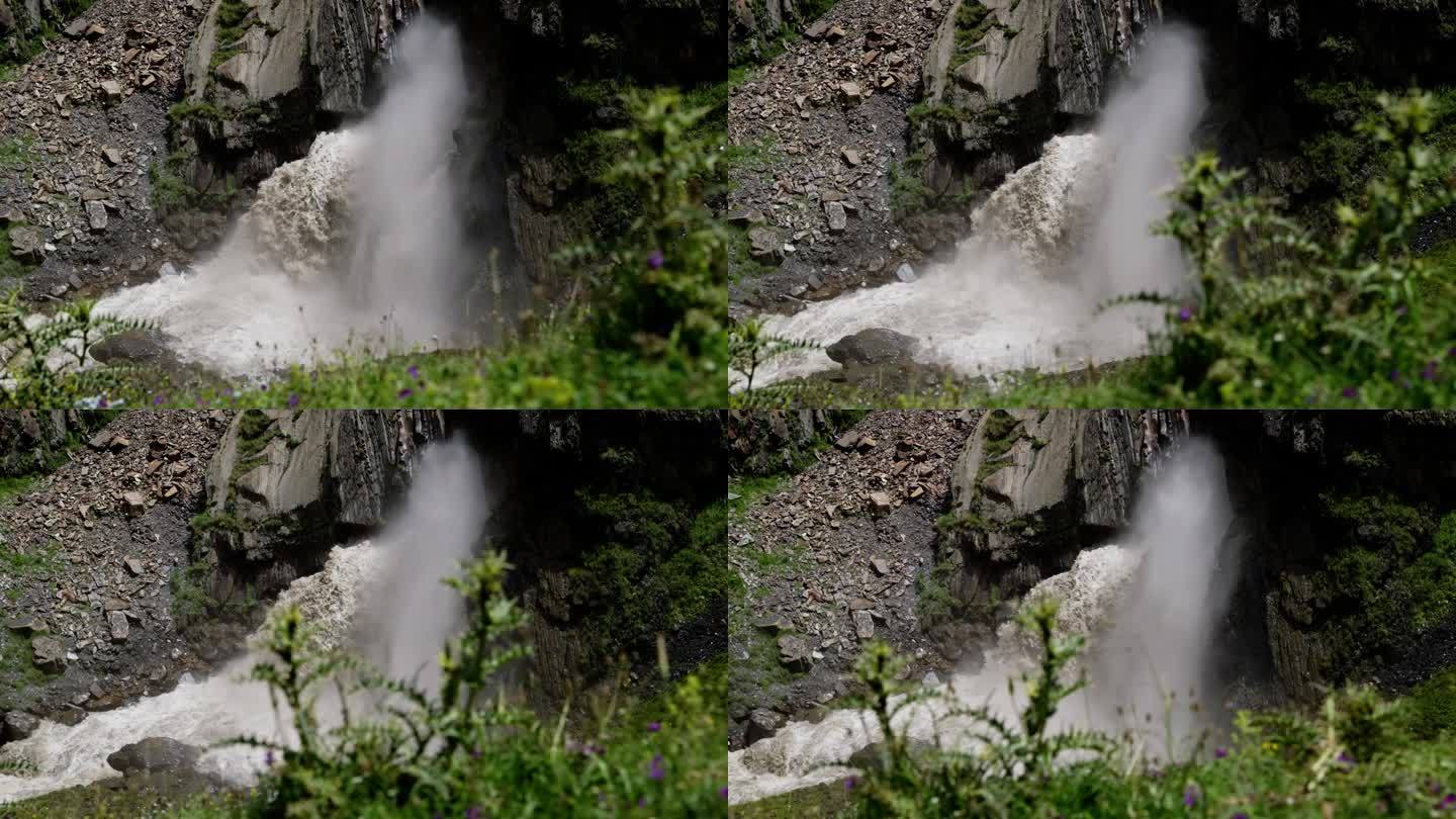 动感的瀑布与下面的河流碰撞，形成雾蒙蒙的浪花，与绿色植物相映成趣