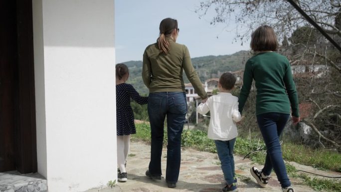 一家人带着三个孩子在旅游村里享受着自然美景和户外清新的空气
