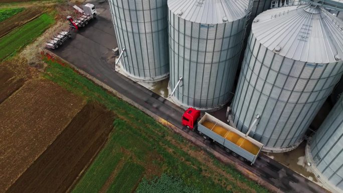 无人机拍摄农村农场的粮仓装满拖车卡车