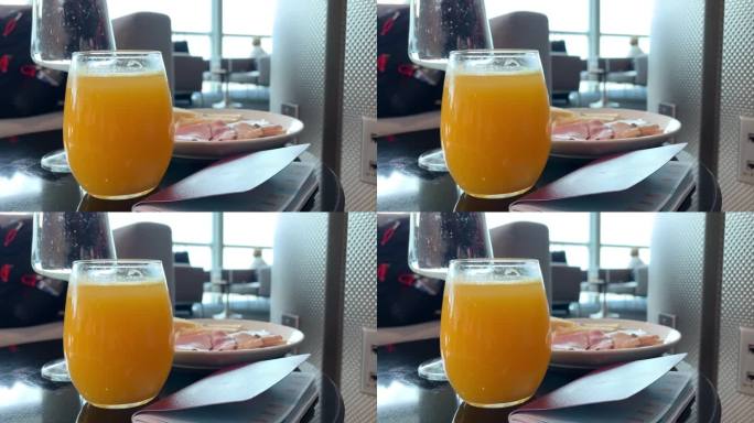 在机场的贵宾休息室享受豪华小吃熟食店:橙汁、苏打水和一桌火腿和各种奶酪。