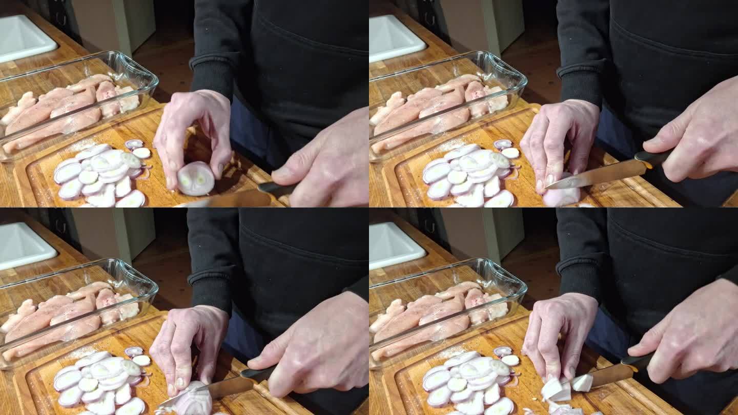 把去皮的洋葱切成圆。一名男子在砧板上切去皮的洋葱。准备在厨房烤箱里烤的鸡块。烹饪和烹饪的概念。