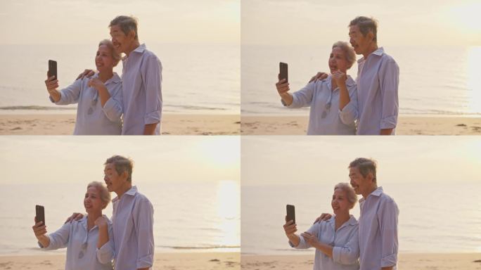 一对老年夫妇在日落时分用智能手机在海滩上视频通话。