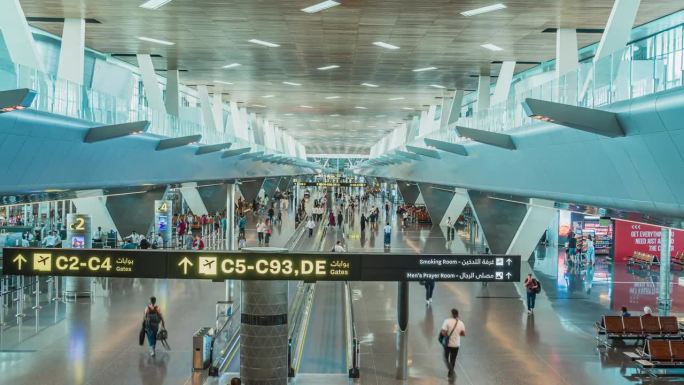 长时间曝光拥挤的通勤游客在卡塔尔多哈国际机场在高峰时间行走，人们移动的延时摄影，旅游和交通的概念