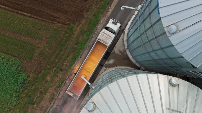 无人机拍摄农村农场的粮仓装满拖车卡车