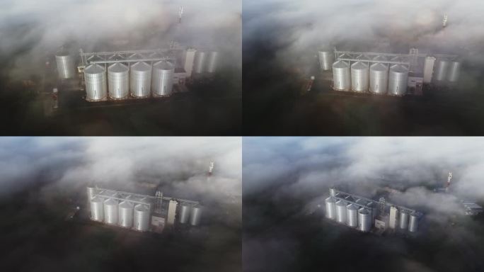无人机在清晨农场的筒仓上拍摄了空灵的雾