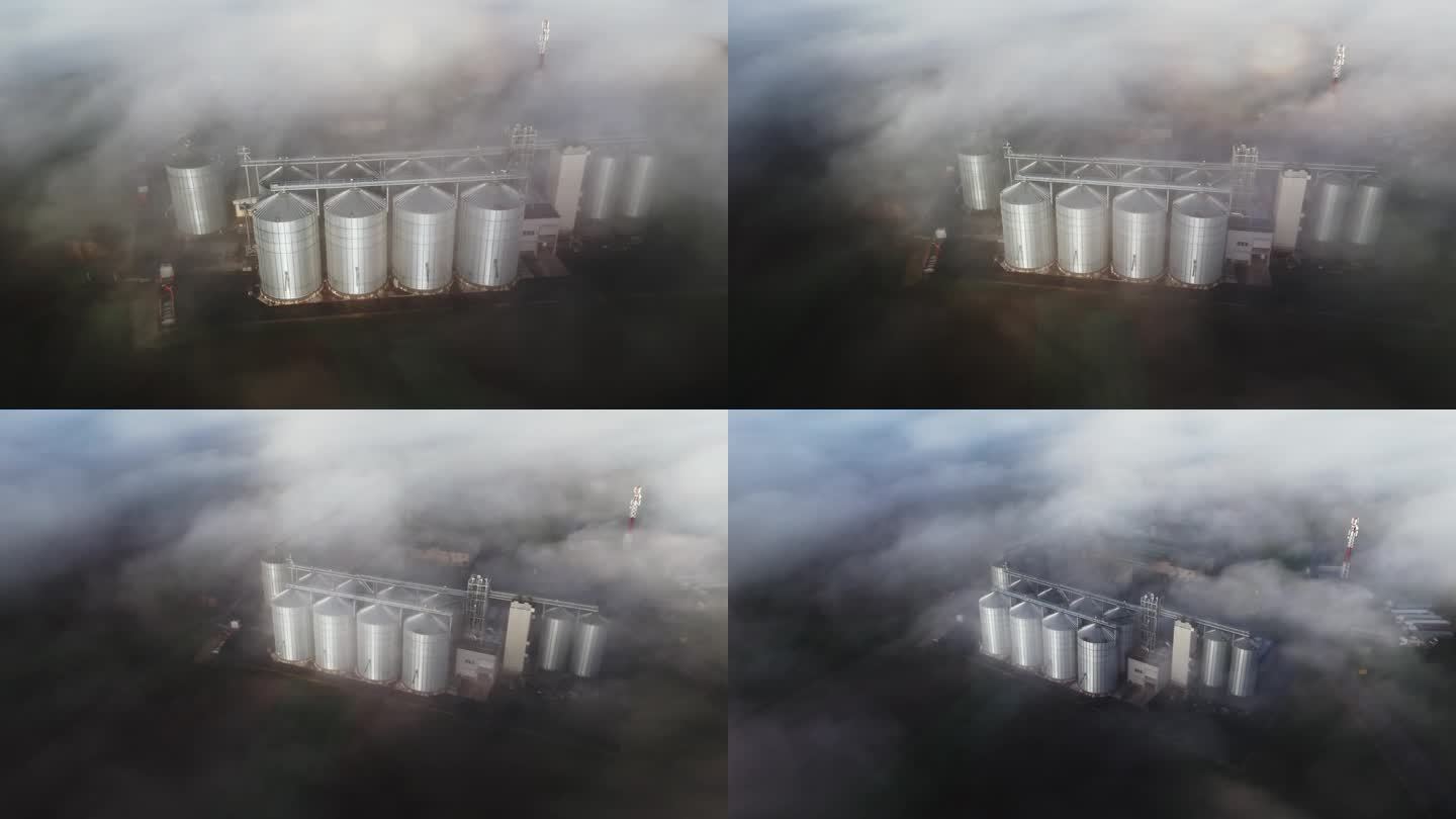 无人机在清晨农场的筒仓上拍摄了空灵的雾