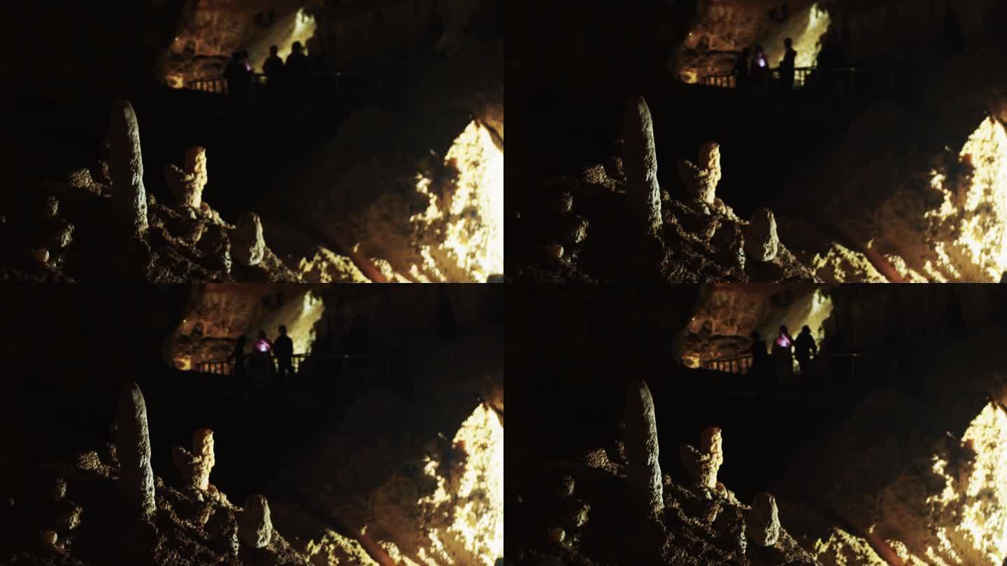 一群游客走过洞穴里桥上的石笋