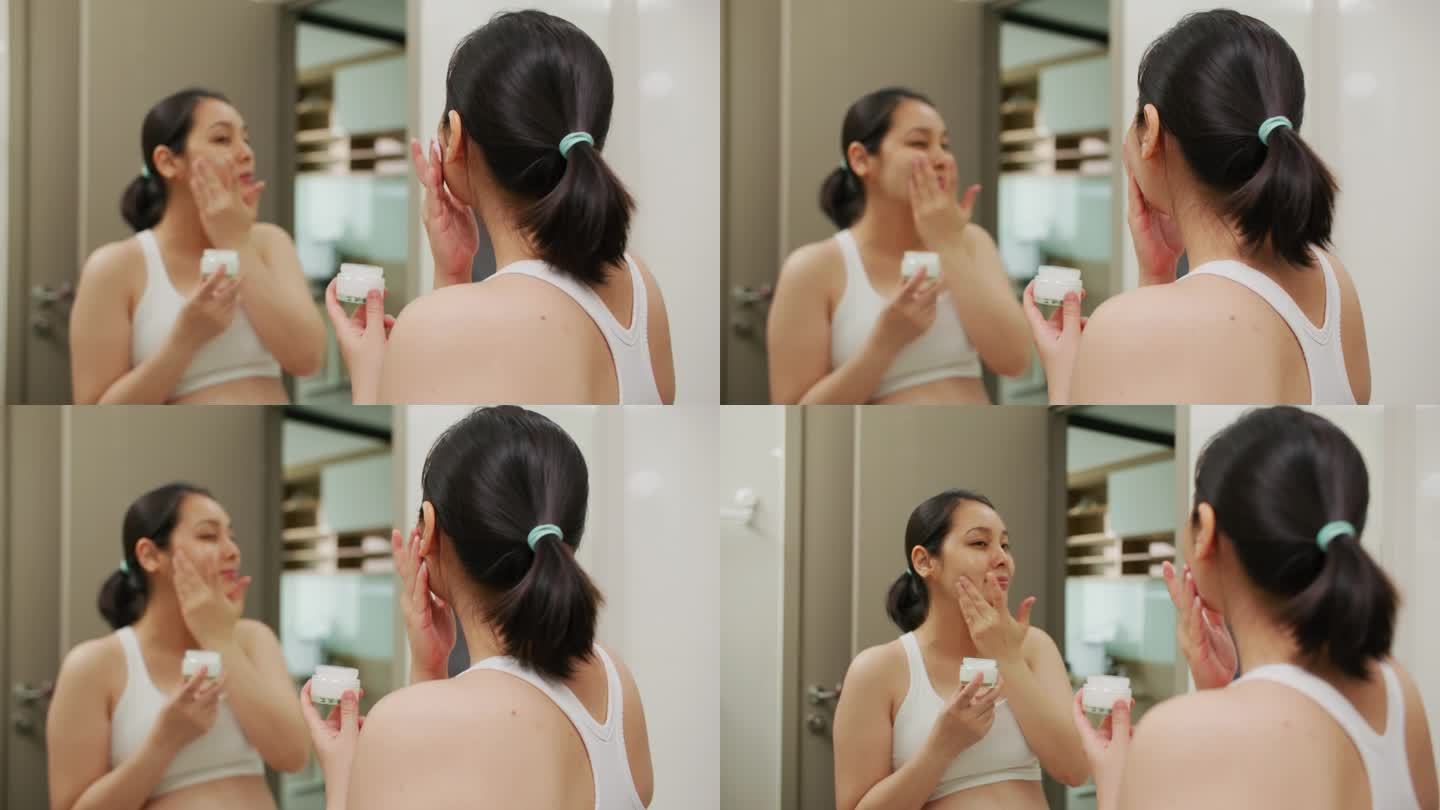 亚洲年轻女子在脸上涂抹润肤霜