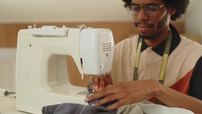 黑人专家在工作室里摆弄缝纫机