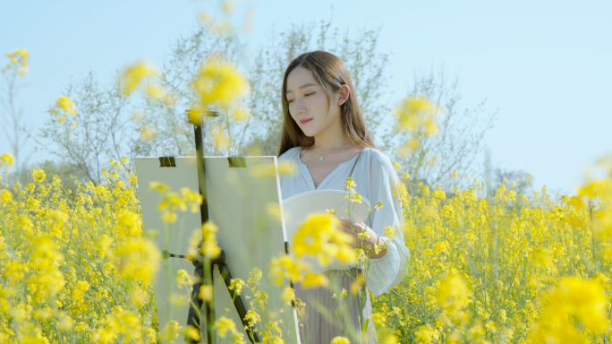 油菜花田里少女画画写生唯美清新