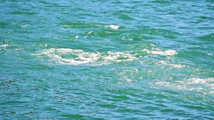 夏天阳光下碧绿海面碧波荡漾水波纹背景