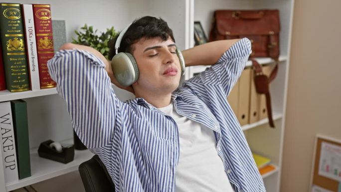 放松的年轻人戴着耳机，在舒适的办公环境中放松，表现出随意的工作日轻松。