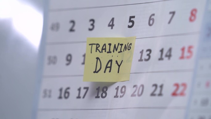 一个女人在日历上标记一天，计划一个月去健身房锻炼。