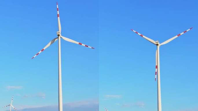 空中可再生能源之间的向日葵田:庄严的风力涡轮机站在向日葵田宁静的无人机镜头