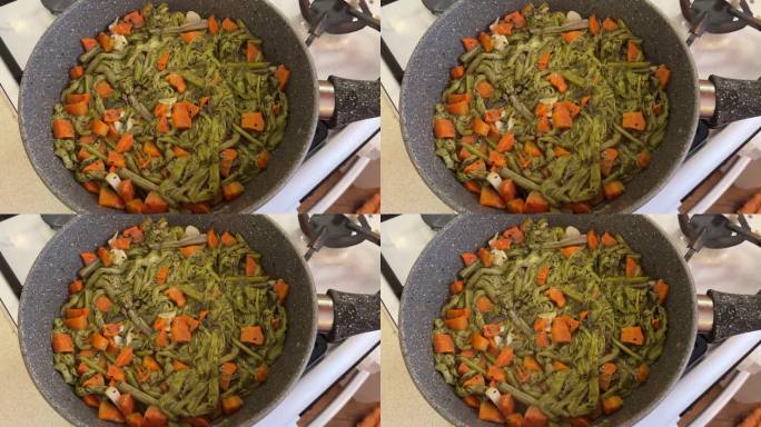 在煤气炉上用煎锅，用洋葱和胡萝卜烤蕨菜。健康饮食。近距离