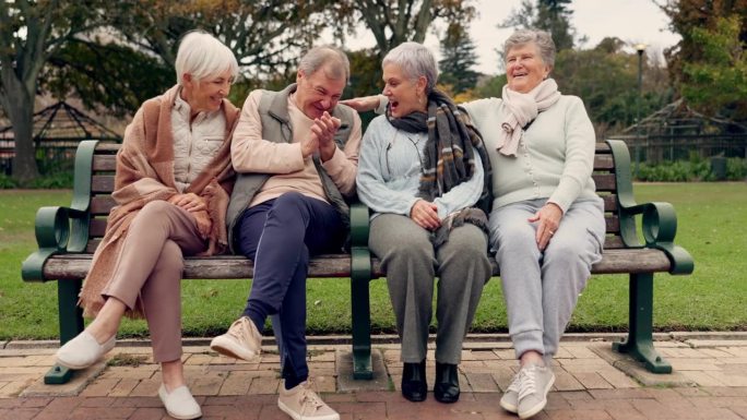 聊天，笑和老人朋友在公园里坐在长椅上呼吸新鲜空气，同时团结在一起。快乐，微笑，一群退休老人在户外的绿