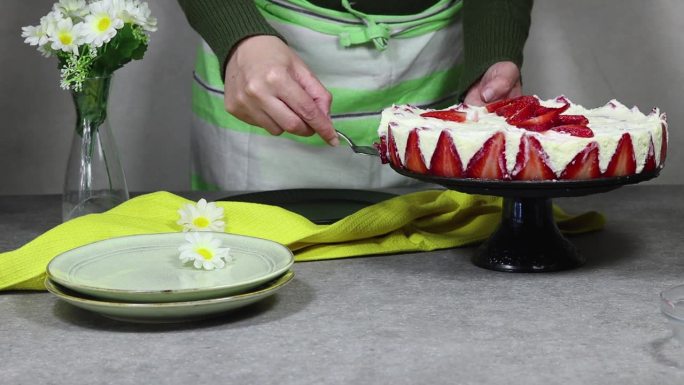 一名妇女正在用黑色盘子端上一份草莓蛋糕或法语Fraisier