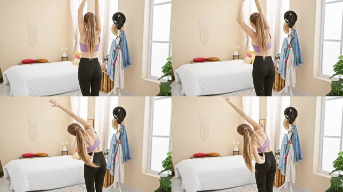 一位穿着运动服的年轻女子在卧室里伸展身体，在空气清新、植物装饰的室内环境中展现出活力和健康的生活方式