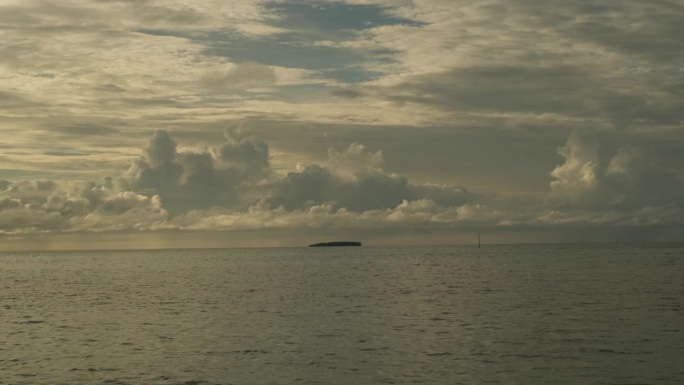 日落时平静的海浪。美丽的暴风雨前多云的天空为背景。