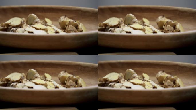 漂亮的淘金镜头，新鲜的生姜片在一个棕色的碗有机收获生姜药用香料