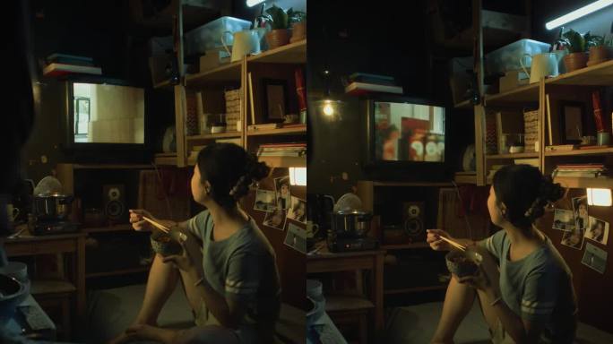韩国女孩在微公寓吃炒菜和看电视广告