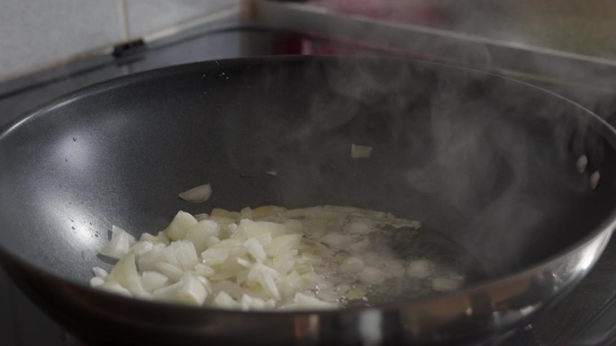 切碎的洋葱在平底锅里用植物油煎，偶尔搅拌一下。特写镜头
