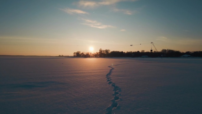 阳光明媚的冬天，洁白的雪上留下的脚印，冰雪覆盖的湖面上留下的动物脚印