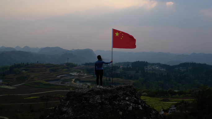 女孩山顶举旗红旗飘飘五星红旗迎风飘扬爱国