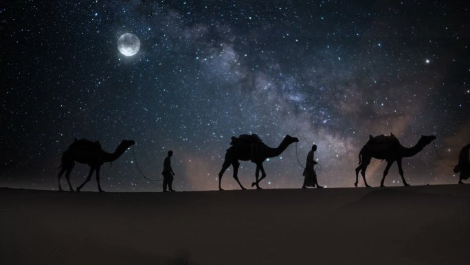 牵着骆驼的阿拉伯人在夜晚行走