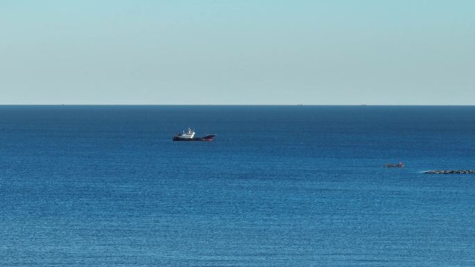 一艘渔船在蓝色的大海海洋中漂洋
