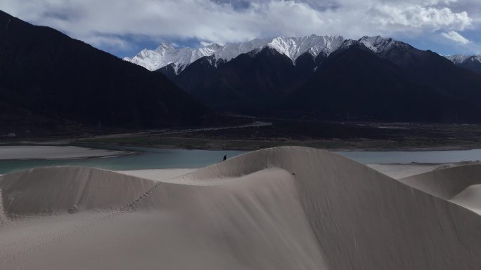 西藏林芝佛掌沙丘电影感人物沙漠雪山背景