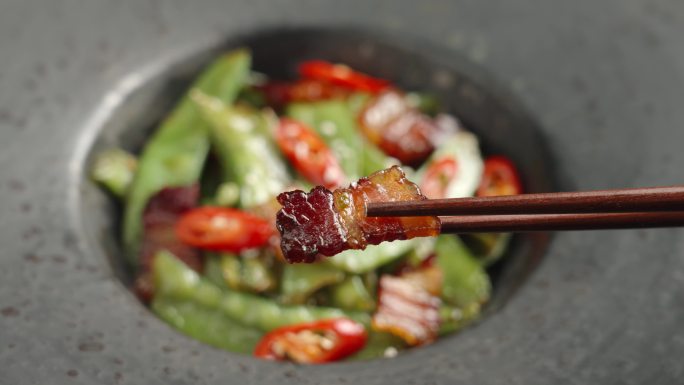 筷子夹起一片腊肉美食特写