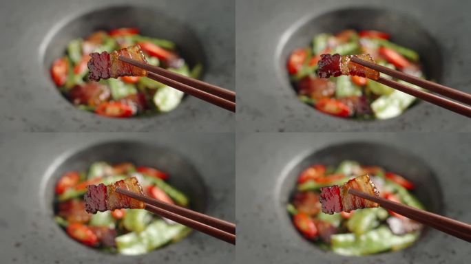 筷子夹起一片腊肉美食特写