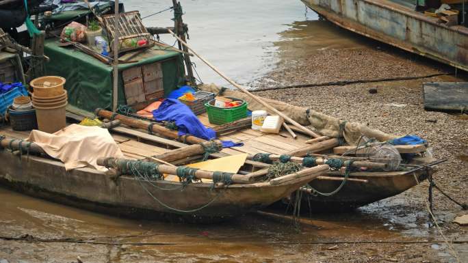 停靠滩涂码头上的破旧渔船小船
