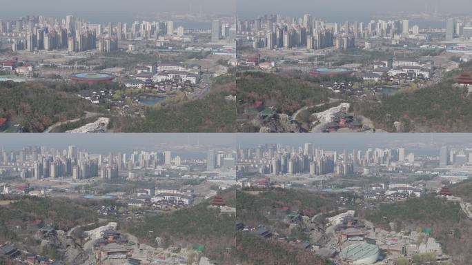 航拍威海华夏城景区春季山野与经区城市高楼