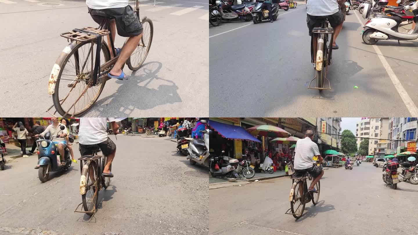 老式自行车脚蹬骑着自行车男子路过城市街道
