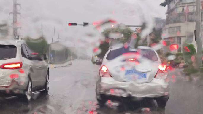 雨点滴在挡风玻下雨水珠流走雨点打在玻璃上