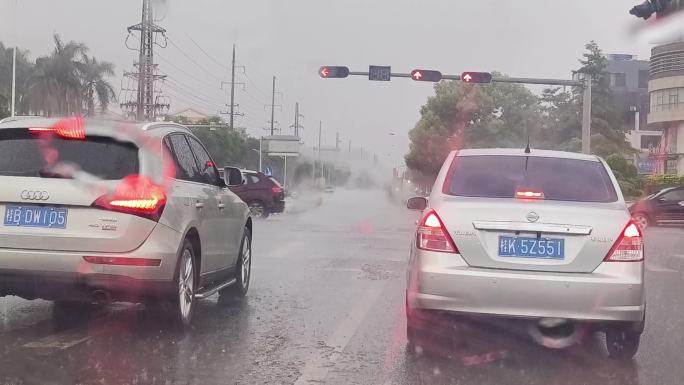 等红绿灯的车辆挡风玻下雨水珠雨点打在玻璃