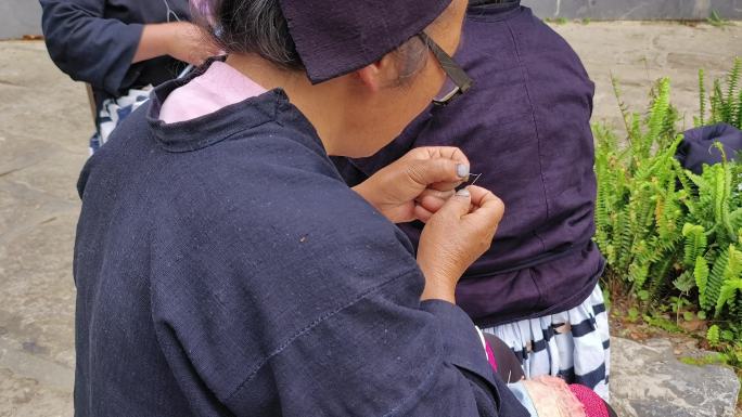 针线活穿针的手头饰织布手部特写原始纺织机