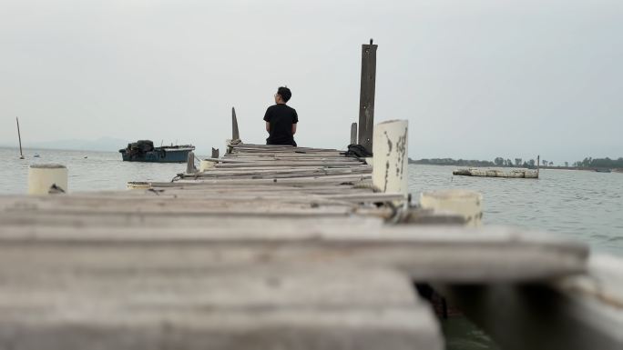 一个人安静的坐在码头看海