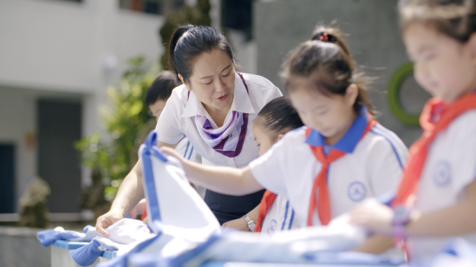 学校小学生和老师做游戏下课做劳动叠衣服