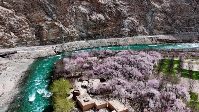 碧绿的河流穿过新疆杏花村 公路边鲜花盛开