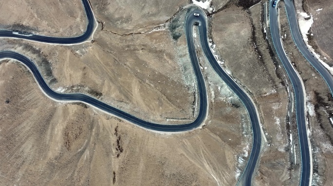 汽车行驶在蜿蜒的山路上新疆盘龙古道航拍