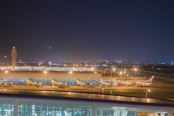 夜晚深圳机场航站楼和飞机落地灯光轨迹