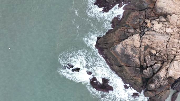 海岸礁石海水拍打礁石阴天海滩岩石海浪冲刷