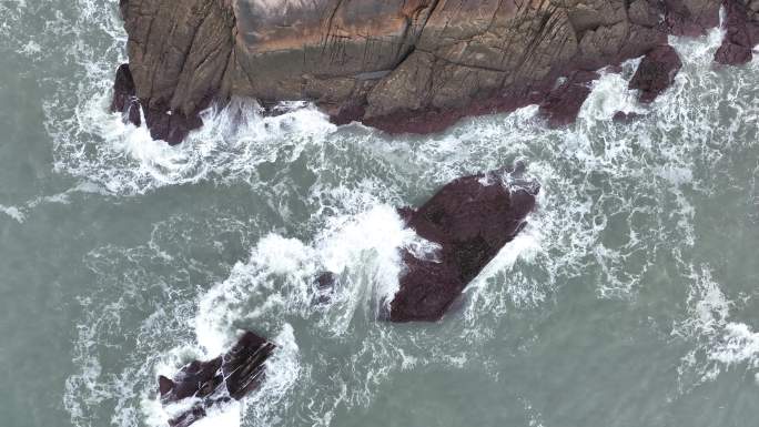 海岸礁石海水拍打礁石阴天海滩岩石海浪冲刷