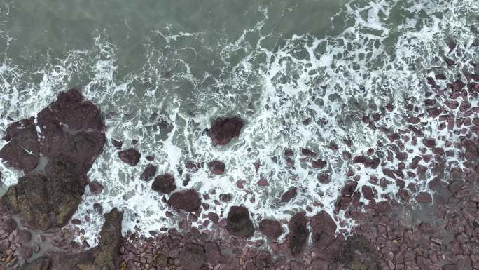 海岸礁石沙滩海水拍打礁石阴天海滩海浪冲刷