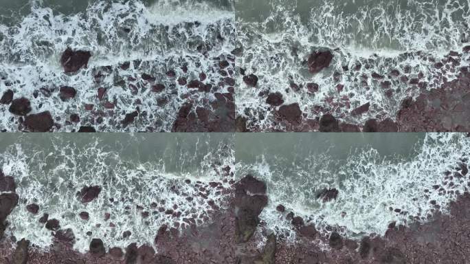 海岸礁石沙滩海水拍打礁石阴天海滩海浪冲刷